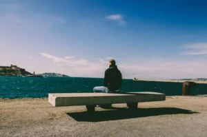 رجل يجلس متأملا في البحر لا يعرف مع من يشارك أفكاره ومخاوفه