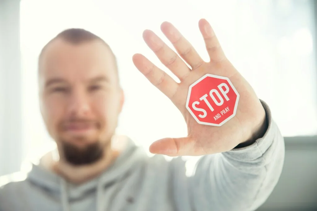 A man showing a stop sign as a demand to stop pleasing people