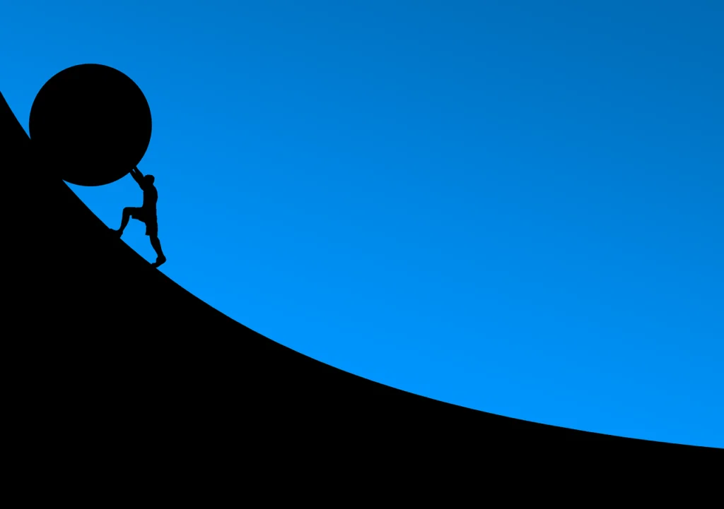 A man is pushing a stone uphill as a symbol of perseverance