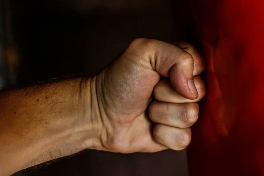 a closed fist hitting a red wall