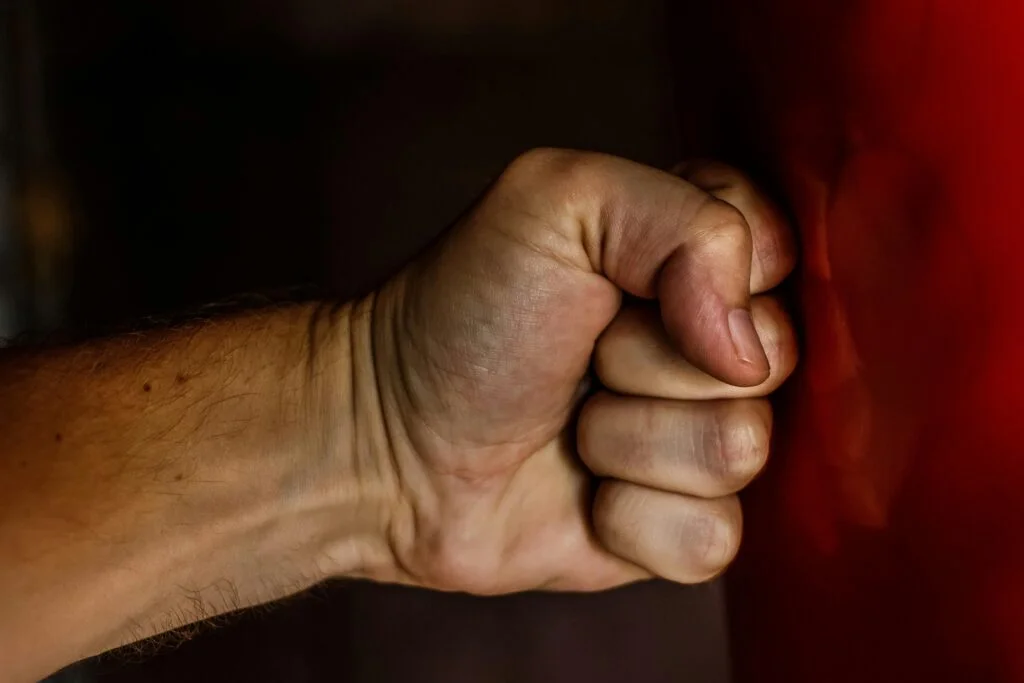 a closed fist hitting a red wall