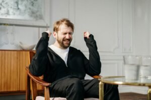 A distressed man in a psychotherapy session in a clinic wearing black