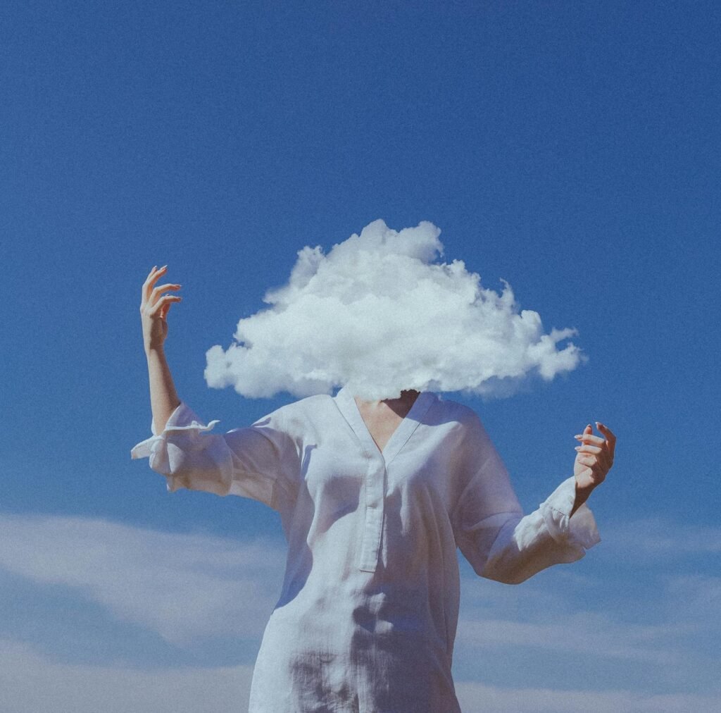 A woman wearing white blouse and hiding her head in the cloud